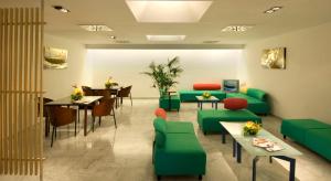 a waiting room with green furniture and a table and chairs at Hotel Nautico in Santa Cruz de Tenerife