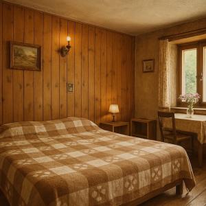 Un dormitorio con una cama y una mesa y una ventana. en Auberge La Cleida, en Névache