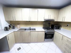 a kitchen with wooden cabinets and a sink and a stove at Beachfront Luxury Stay with private beach 2 bedroom in Ras al Khaimah