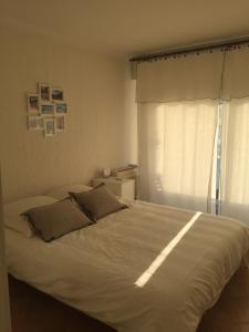 a white bed in a bedroom with a window at Immeuble le St Honorat in Cannes