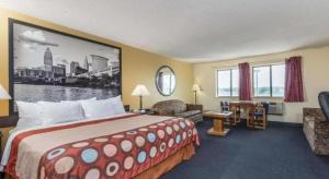 米德尔敦Super 8 By Wyndham Franklin/Middletown Area的配有一张大床和一把椅子的酒店房间