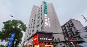 un alto edificio bianco con una scritta sopra su una strada di City Comfort Inn Changsha Railway Station a Changsha