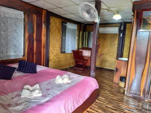 Ban Khlong TakhianJidapa Resort的一间卧室配有粉红色的床和毛巾