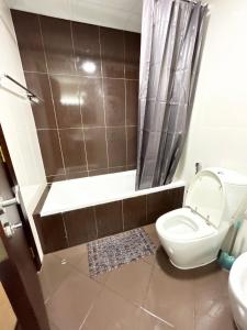 a bathroom with a toilet and a shower and a sink at Bab Al Bahr 2 BR Apartment in Ras al Khaimah