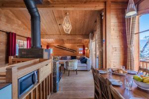 una cucina e una sala da pranzo con una stufa in una cabina di Cosy 4 bedroom chalet with hot tub (Chalet Velours) a Saint-Marcel