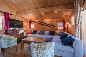 un soggiorno con un divano e una TV di Cosy 4 bedroom chalet with hot tub (Chalet Velours) a Saint-Marcel