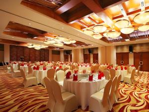 a large banquet hall with white tables and chairs at Man Wan Harmona Resort in Youcaopeng +259 photos