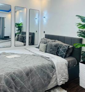 Un dormitorio con una cama grande con tres espejos. en Club Balai Isabel - Audrey-Adam Staycation Balai, en Sampong