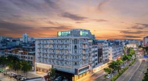 东兴City Comfort Inn Dongxing National Trade Port的一座白色的大建筑,上面有钟