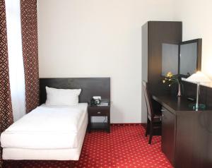 a hotel room with a bed and a desk and a bed at Aariana Hotel in Offenbach