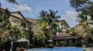 ein Hotel mit einem Swimmingpool vor einem Gebäude in der Unterkunft The Oxalis Regency Hotel in Magelang
