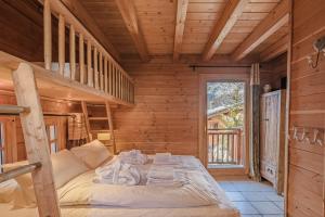 una camera con letto a castello in una baita di tronchi di Cosy 4 bedroom chalet with hot tub (Chalet Velours) a Saint-Marcel