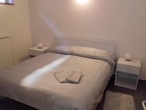 ein kleines Schlafzimmer mit einem Bett mit zwei Nachttischen in der Unterkunft Ca du Chicco in Cannero Riviera