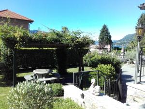 einen Garten mit einer Bank, einem Tisch und einem Zaun in der Unterkunft Ca du Chicco in Cannero Riviera
