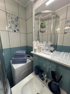 ein Badezimmer mit Waschbecken, Toilette und Spiegel in der Unterkunft Apartament Central Ilie Balaci 15 in Craiova