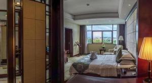黄山市Huangshan International Hotel的一间卧室，里面有一张床和一扇大窗户。 更多278张照片