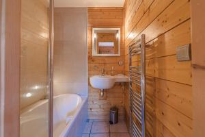 un bagno con vasca, lavandino e vasca da bagno di Cosy 4 bedroom chalet with hot tub (Chalet Velours) a Saint-Marcel Altre 32 foto