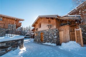 una baita di tronchi in inverno con neve a terra di Cosy 4 bedroom chalet with hot tub (Chalet Velours) a Saint-Marcel