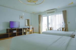 Mỹ ÐucParacel Resort Hai Tien的一间配有两张床和一台平板电视的酒店房间