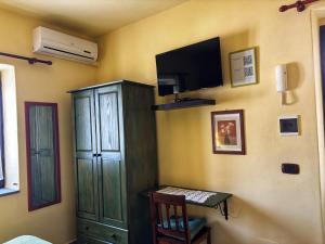 sala de estar con TV y armario en Salina Acroeoliano monolocali in villa, en Leni