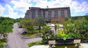 un grande edificio con palme in un parcheggio di Labersa Grand Hotel &Convention Center a Parit