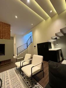 a living room with two chairs and a staircase at luxury basement studio in Riyadh
