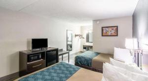 a hotel room with two beds and a flat screen tv at Econo Lodge Crestview South in Crestview