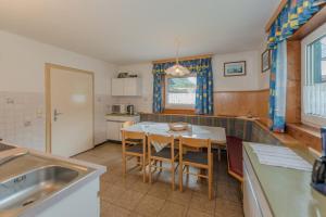 eine Küche mit einem Tisch und Stühlen im Zimmer in der Unterkunft Ferienhaus Evi in Schladming