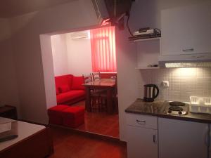 a living room with a red couch and a table at Villa Bosac in Gradac