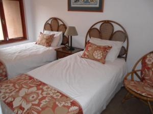 ein Hotelzimmer mit zwei Betten und einem Stuhl in der Unterkunft San Lameer Villa 2012 in Southbroom + 29 Fotos