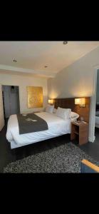 una camera da letto con un grande letto bianco e un tavolo di La Maison de l Echauguette Petit Dejeuner et Menage Offerts a Clermont-Ferrand