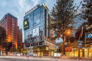 ein hohes Gebäude mitten in einer Stadt in der Unterkunft ibis Styles Kunming Nanping Hotel in Kunming