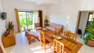 luxury villa in Nosy Be Ambaro في Ambaro: غرفة معيشة مع طاولة وكراسي وأريكة