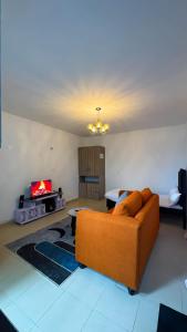 un soggiorno con un divano e una TV di Pamsal Studio a Thika