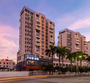 duży budynek z palmami przed nim w obiekcie H Life Hotel (Shenzhen Sea World Branch) w mieście Shenzhen