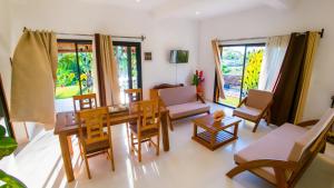 luxury villa in Nosy Be Ambaro في Ambaro: غرفة معيشة مع طاولة وكراسي خشبية