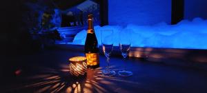 a bottle of wine and two wine glasses on a table at Duplex 7 avec Spa Privé in Herstal