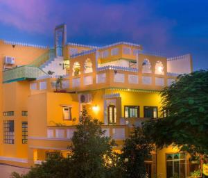 a large yellow building with many windows at night at The Coral Court Homestay in Agra