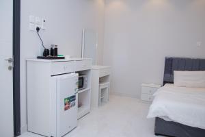 Dormitorio blanco con cama y mostrador blanco en ديلوكس فخامة مكة, en An Nikāshah