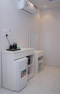 Una cocina blanca con encimera y estufa. en ديلوكس فخامة مكة, en An Nikāshah