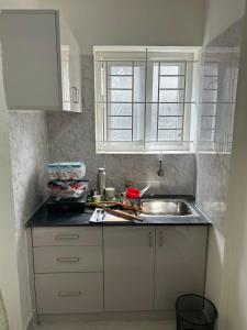 a kitchen with white cabinets and a sink at Vista inn in Bangalore