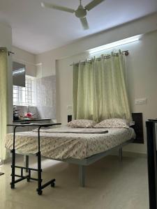 a bedroom with a bed with a window and a table at Vista inn in Bangalore