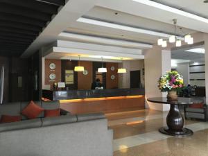 a lobby with a waiting area with a table and flowers at Baguio Burnham Suites Hotel in Baguio