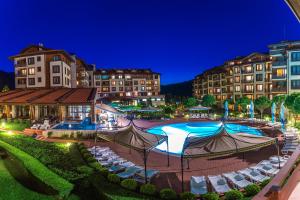 un complejo con piscina, sillas y edificios en Murite Park Hotel, en Bansko