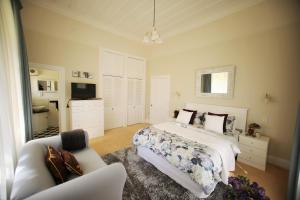 a bedroom with a bed and a couch and a tv at Regan House in Stratford