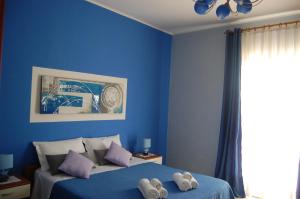 um quarto azul com uma cama com toalhas em OMBRA E CAFFE' em Mascali