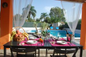 uma mesa preta com uma cesta de frutas ao lado de uma piscina em OMBRA E CAFFE' em Mascali