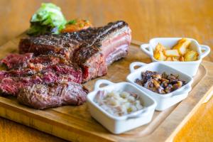 a cutting board with steak and chips and other foods at Hôtel Minvielle - Résidence Les Oliviers in Ségos