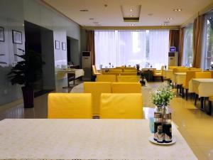 una sala da pranzo con sedie gialle e tavolo con fiori di Jinjiang Inn Jinan Daming Lake a Jinan
