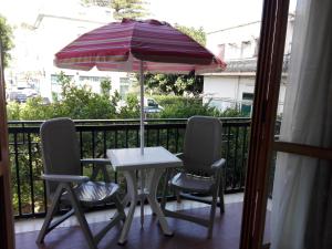 ein Tisch und zwei Stühle und ein Sonnenschirm auf dem Balkon in der Unterkunft Casa Giorgia in Cefalú